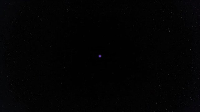 A small blue dot in a dark space against a white background.