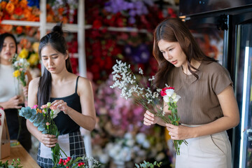 Women florists arranging flowers in bloom flower shop