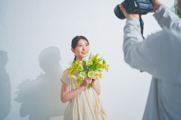 花束を持った美しい20代女性のポートレート撮影風景