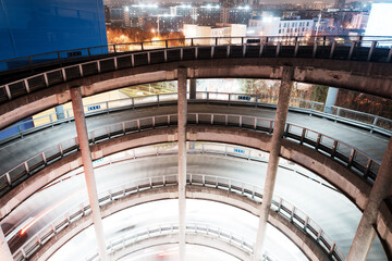 Night view of a modern urban multi-story spiral parking garage.