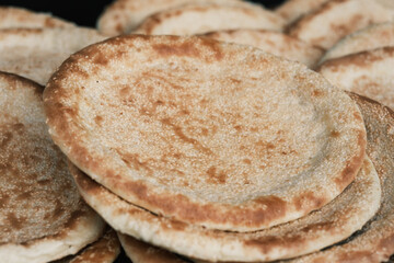 A close-up shot of freshly baked sesame flatbread, a golden and crispy traditional East Asian pastry; food photography.