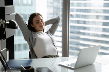Workday victory. Serene smiling millennial woman office worker manager accountant recline back on...