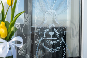 Zero cost responsible holiday decor economically driven. Painted Easter bunny rabbit on window glass indoor at home. Affordable alternative Easter springtime seasonal tradition ideas decoration. Diy