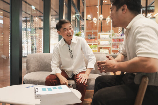 Asia mature business man working with paper work and talking with workmate