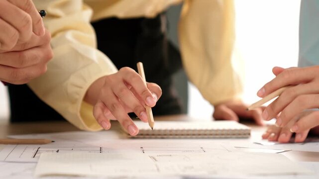 Video of architects or smart engineers use measurement tool, divider and pencil hand writing detail on blueprint for construction accuracy at architectural office. Focus on hand. Closeup. Delineation.