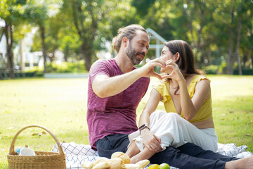 Happy family picnic in the park public on summer holiday.  Family relax and enjoying outdoor.  Family and Lifestyle Concept