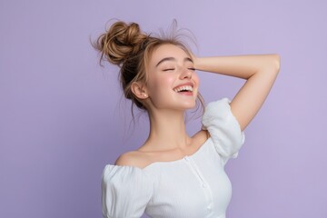 Fototapeta premium Young woman with messy bun hairstyle expresses genuine joy against a light purple background