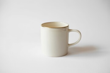 Fototapeta premium Elegant white ceramic mug with gold rim