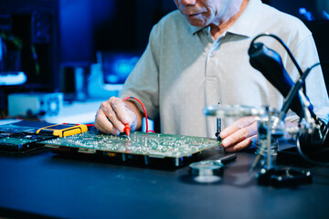 Closeup of expert soldering a green PCB board using precision tools. Ideal for electronics, circuit repair, engineering, tech
