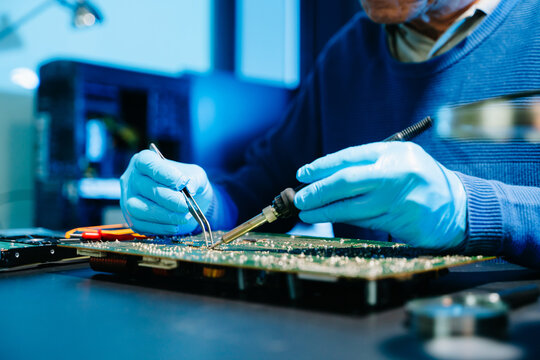 Professional electronics engineer testing a circuit board in a modern laboratory, concept of technology, repair, innovation, engineering - Powered by Adobe