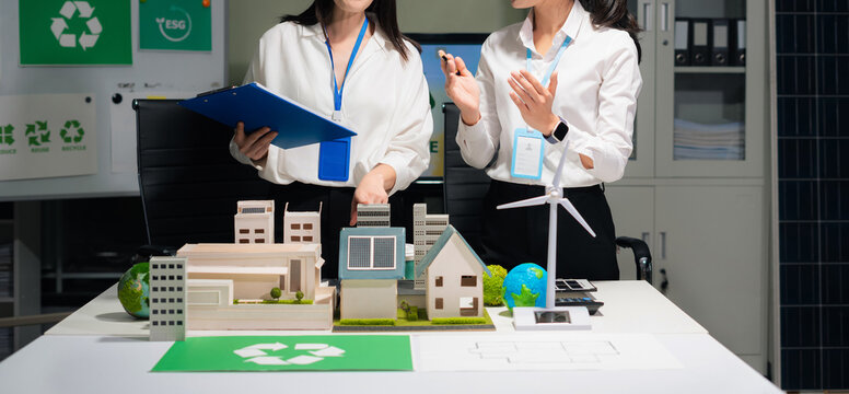 Two colleagues discussing data Construction Site project, green energy and solar panel concept. - Powered by Adobe