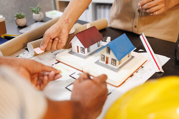 
Two people are working on a house plan design. They are using various tools, working with the...