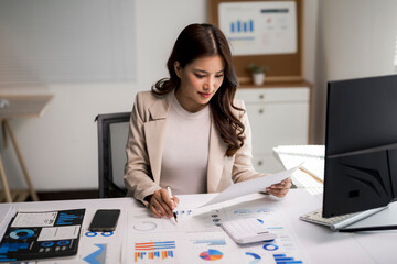 Asian businesswoman analyzing financial data and business charts
