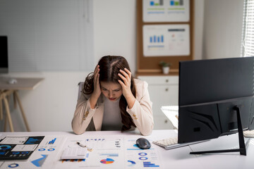 Businesswoman experiencing stress and headache from overwhelming work data