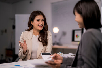 Businesswomen discussing finance and calculating budget in office