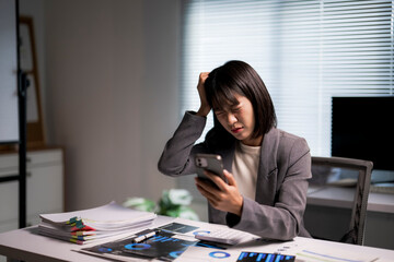 Stressed businesswoman reading bad news on phone