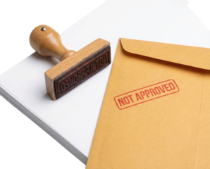 A wooden stamp and an envelope marked "NOT APPROVED," symbolizing rejection or disapproval in administrative processes.