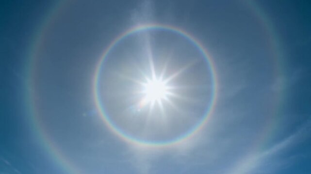 Bright Sun with Stunning 22 Degree Solar Halo in Clear Blue Sky.