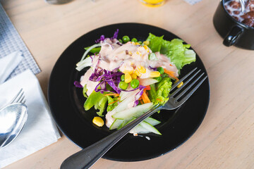 A simple vegetable salad with assorted vegetables, corn, and mayo dressing.