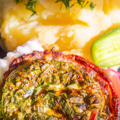Baked meat with cheese and mashed potatoes with fresh vegetables as a side dish