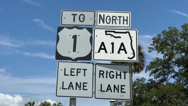 DOLLY SHOT - St Augustine Road Sign. Traffic signs to North, Route 1, A1A, Left Lane, and Right Lane in St. Augustin Historical District, Florida, USA. U.S. Route 1 in Florida.