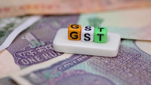 Concept of Goods and Services Taxes (GST) in India created with text objects over Indian rupee currency notes.
