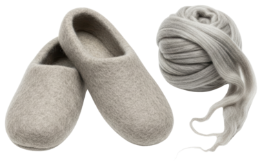 Pair of grey felt slippers next to large ball of grey wool yarn isolated on transparent background