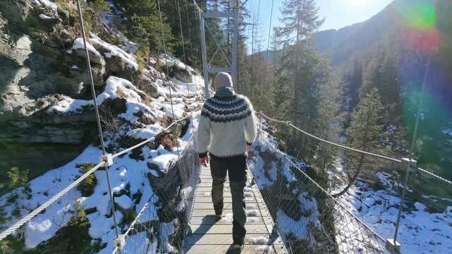Man in Iceland Sweater Walking Through Snowy Forest in Switzerland Drone shot