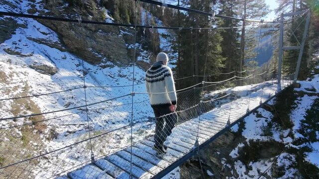 Man in Iceland Sweater Walking Through Snowy Forest in Switzerland Drone shot