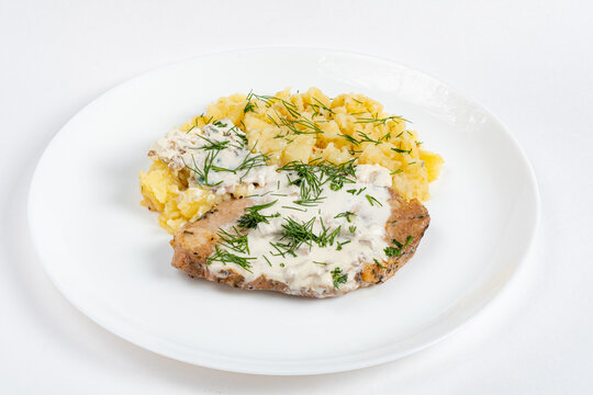 Enjoy tender pork with creamy dill sauce and mashed potatoes for a delightful meal!