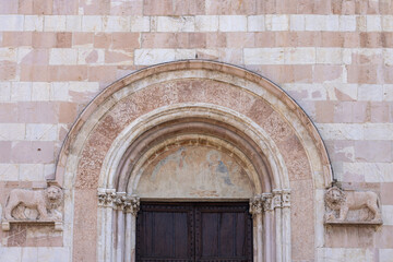 Facade and portal over entrance gate to of Basilica of Saint Clare, gothic roman catholic church, Assisi, Italy