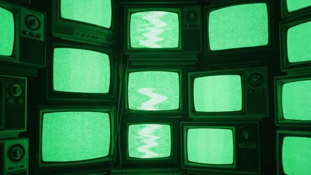 Wall of retro CRT televisions showing green static and glitch patterns