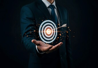 Businessman holding a glowing target with an arrow hitting the bullseye hand dartboard
