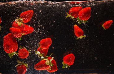 High speed capture of ripe red strawberries suspended in water with dynamic splashes against a dark background. This image conveys freshness, vitality, and healthy food concepts, ideal for culinary, 