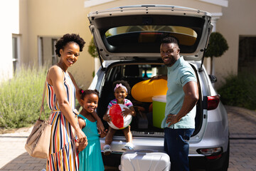 Portrait of african american family smiling while standing near their car © wavebreak3