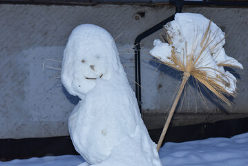 Snowman with broom in winter