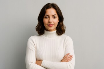 Fototapeta premium Confident young woman in white turtleneck poses with crossed arms on neutral background, representing strength and self-assurance concept. Ai generative