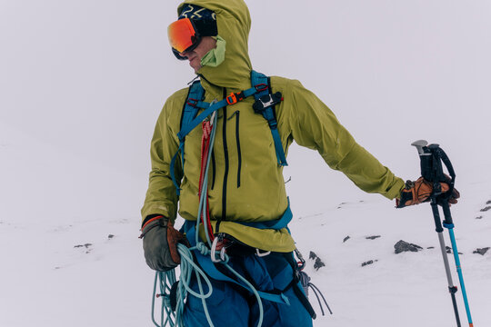 A skier crosses a glacier on a stormy day.
