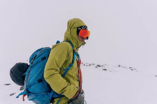 A skier crosses a glacier during a snowstorm.