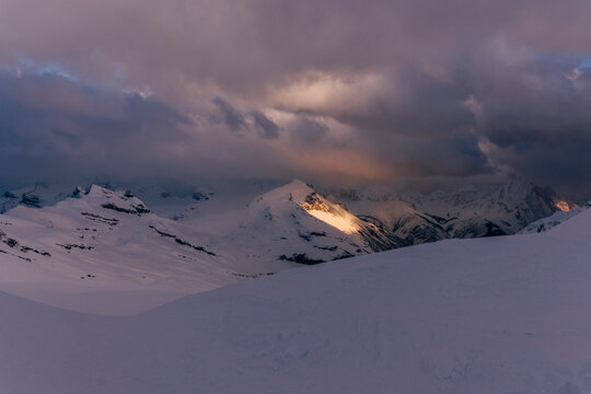 Light illuminates a mountain in the Northern Rockies of Canada.