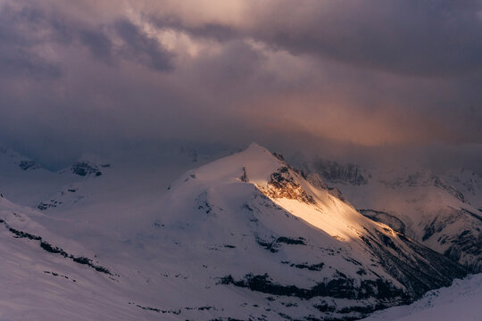 Light illuminates a mountain in the Northern Rockies of Canada.
