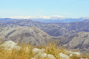 Panoramic view of snow-capped Mount Durmitor peaks from an Orjen Nature Park hiking trail in Montenegro. Symbolizes alpine wilderness exploration, Balkan mountain tourism, and scenic trekking routes.