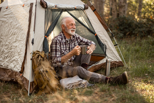 Senior man relaxing and enjoying camping in nature