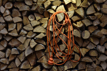 Orange extension cord on woodpile