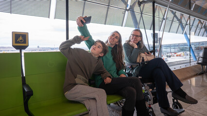 Family taking selfie while waiting in accessible airport terminal