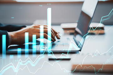 Business analyst typing on laptop with financial graphs overlayed on screen in modern office showing stock growth and market data concepts.