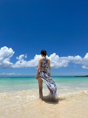 Woman Standing in the Sea on a Tropical Beach Under Blue Sky