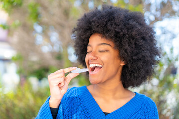 Fototapeta premium African American girl at outdoors holding invisible braces