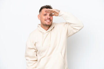 Young caucasian handsome man isolated on white background looking far away with hand to look...