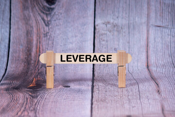 Fototapeta premium Leverage symbol. Single Wooden stick supported by Clothespins, beautiful Light Orange tone highlight Wooden Texture Background. Business and Leverage concept with copy space